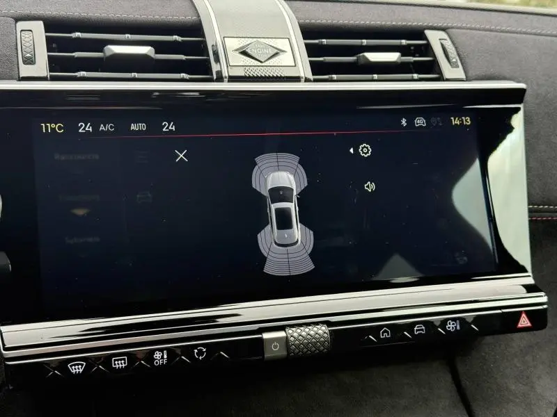 Écran tactile central du DS7 E-TENSE 2024 montrant l'aide au stationnement, avec finition intérieure noire et détails chromés.