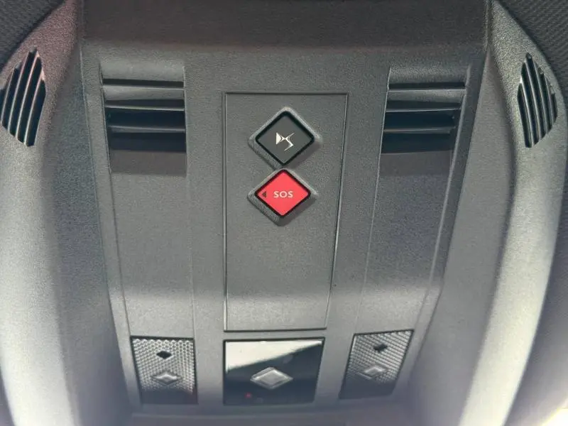 Vue rapprochée du panneau de commandes au plafond intérieur du DS7 E-TENSE gris 2024, avec bouton SOS rouge et silencieux.
