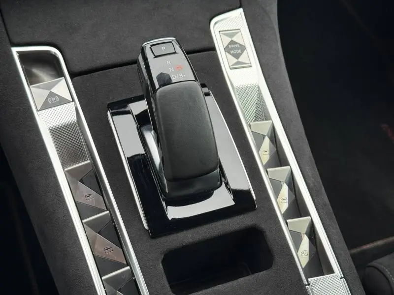 Gros plan sur la console centrale du DS7 E-TENSE 225ch gris 2024, avec levier de vitesses automatique et commandes en métal brossé.