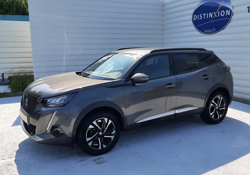 Peugeot 2008 gris Artense en 3/4 avant droit, avec jantes noires et toit panoramique visible.