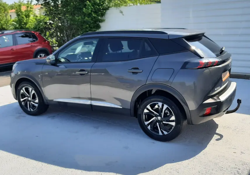 Peugeot 2008 gris Artense vue de profil côté gauche, avec toit noir et jantes alliage distinctives.