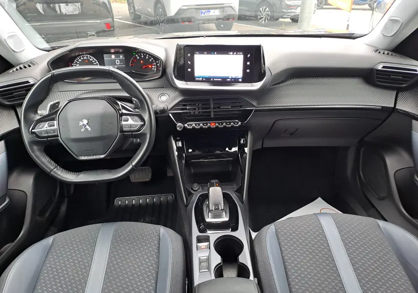 Intérieur noir du Peugeot 2008 2020, vue frontale sur le tableau de bord avec écran tactile et volant compact.