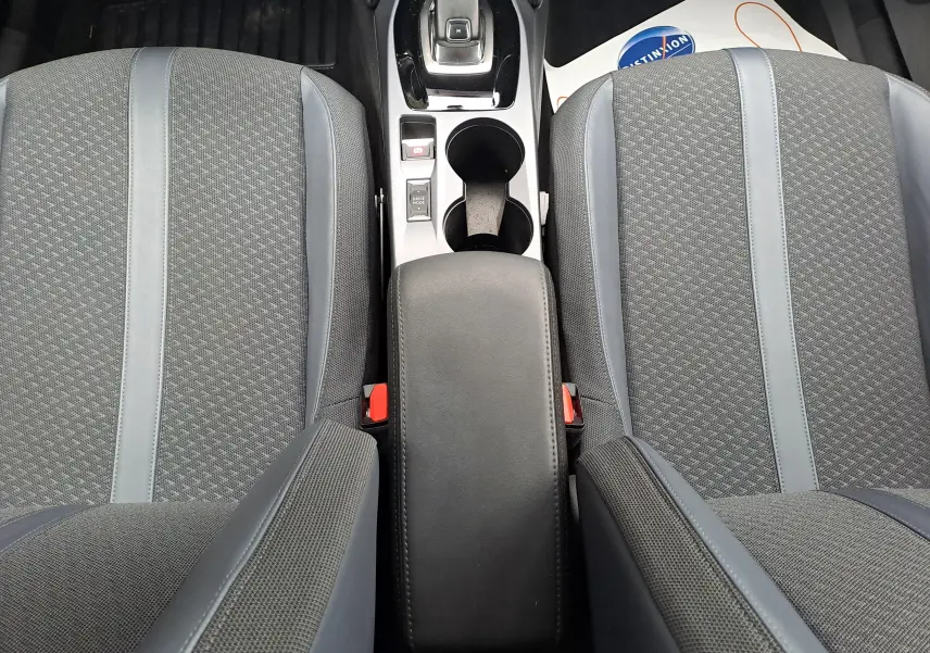 Vue plongeante sur les sièges avant gris tissu et cuir avec accoudoir central et console d'une Peugeot 2008 2020.