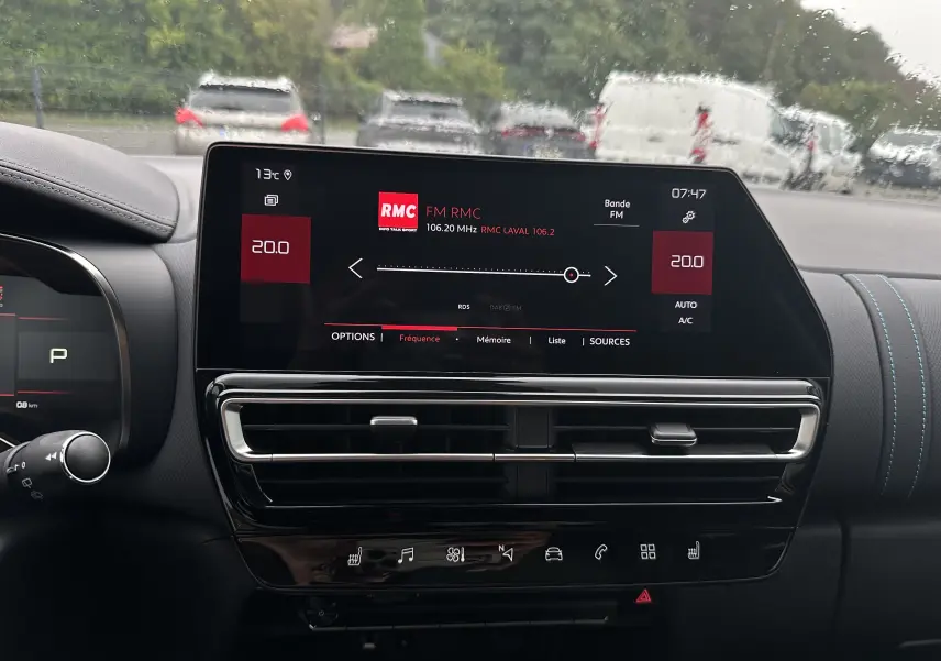 Tableau de bord du Citroën C5 Aircross 2025, écran tactile central affichant la radio RMC, ambiance noire avec surpiqûres bleues