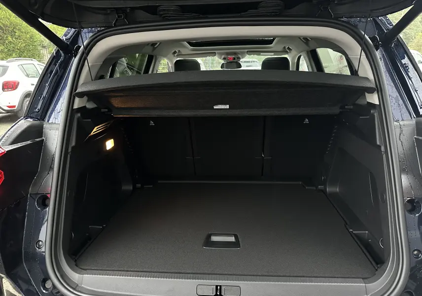 Vue arrière du coffre ouvert du Citroën C5 Aircross Bleu Eclipse 2025 avec hayon électrique et cache-bagages.