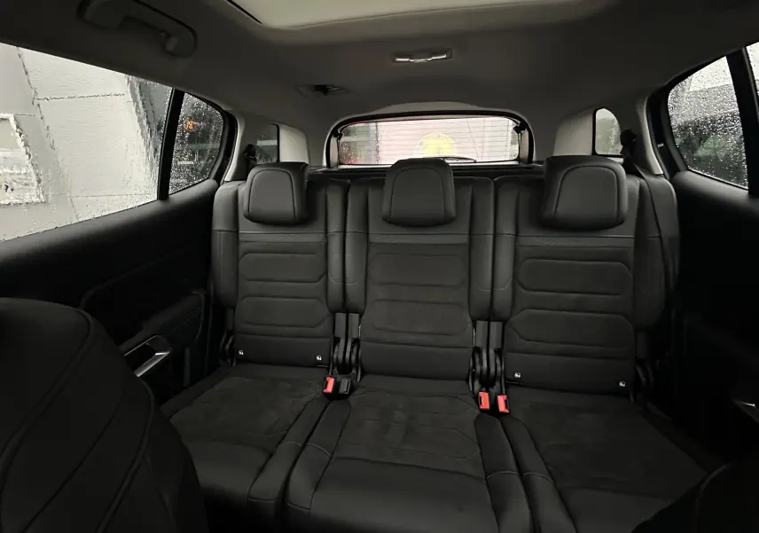 Vue intérieure arrière du Citroën C5 Aircross 2025 montrant les trois sièges arrière en cuir noir avec appuie-têtes intégrés.