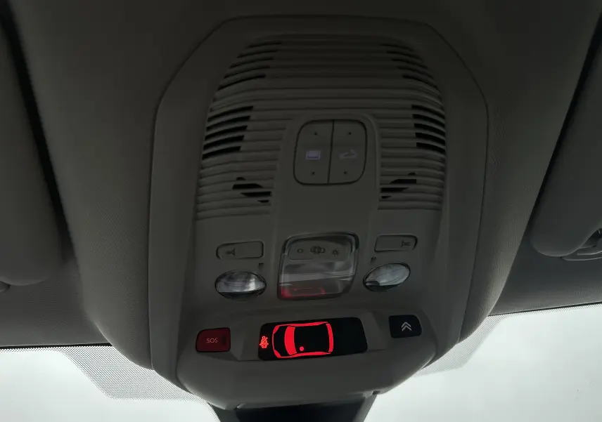 Vue en gros plan du plafonnier intérieur gris du Citroën C5 Aircross 2025 avec boutons éclairage et alerte SOS rouge.