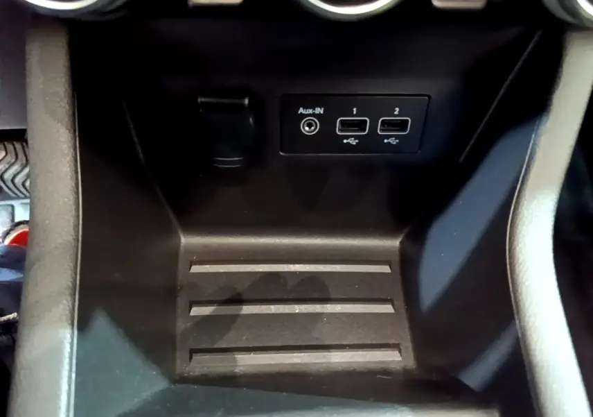Gros plan sur la console centrale noire de la Renault Clio Business TCe 100 avec ports USB et prise Aux-IN.