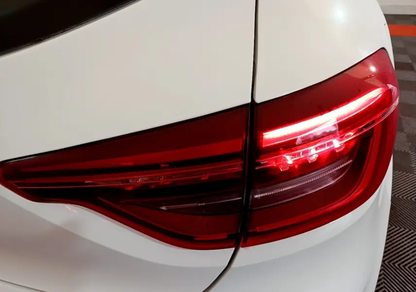 Gros plan sur le feu arrière droit rouge d'une Renault Clio Business TCe 100 blanche de 2020.