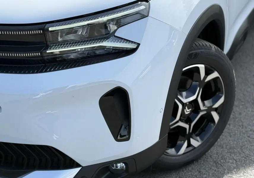 Gros plan 3/4 avant droit du Citroën C5 Aircross blanc Okenite, avec phare LED et jante alliage bi-ton noire et argent.