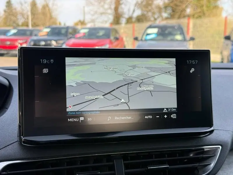 Écran tactile central du Peugeot 3008 2024 affichant la navigation, avec tableau de bord noir visible en arrière-plan.
