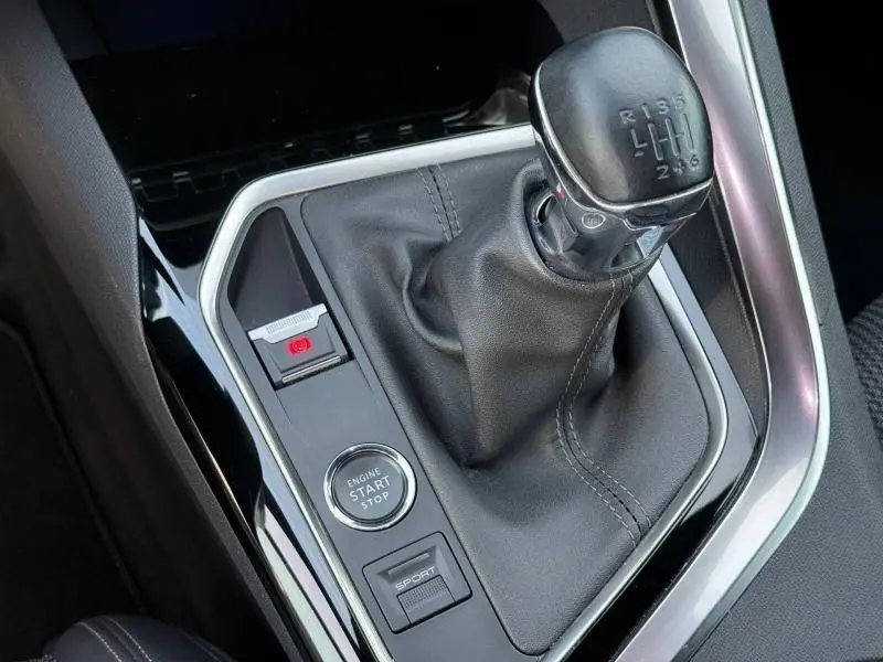 Gros plan sur la boîte manuelle et la console centrale du Peugeot 3008 2024 avec bouton start/stop et mode sport.