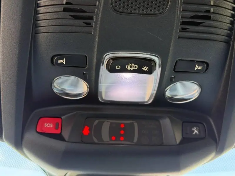 Gros plan sur la console de toit intérieure du Peugeot 3008 2024, avec boutons d’éclairage et alerte SOS visibles.