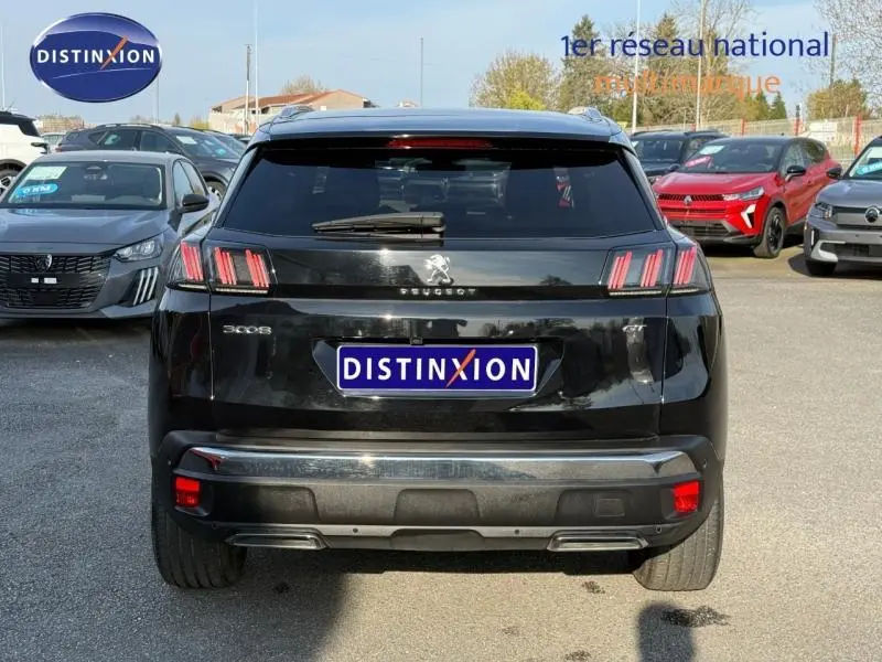 Vue arrière d’un Peugeot 3008 2024 noir Black Diamond avec feux LED caractéristiques et logo central sur parking.