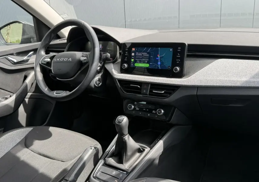 Intérieur de la Skoda Scala TSI 116 gris graphite, vue côté conducteur avec tableau de bord et écran tactile central.