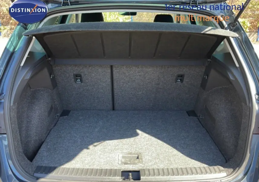 Coffre ouvert vu de l’arrière d’un SEAT Arona gris Magnetic Metal avec toit noir, montrant l’espace de chargement vide.