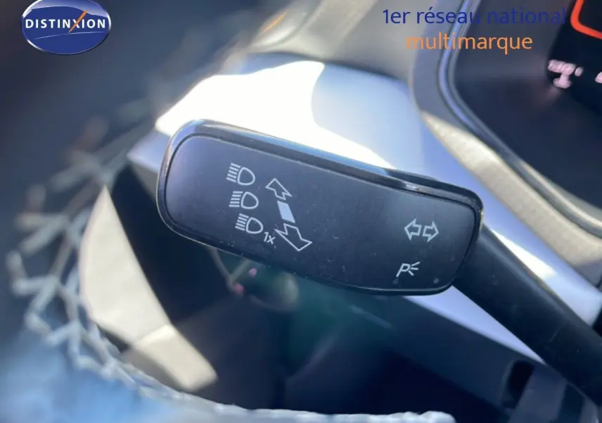 Levier de clignotant et feux du SEAT Arona 2025 en gros plan, intérieur gris et noir visible en arrière-plan.