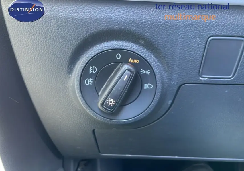 Gros plan sur le sélecteur de phares du tableau de bord d’un SEAT Arona 2025 gris magnetic metal avec toit noir.
