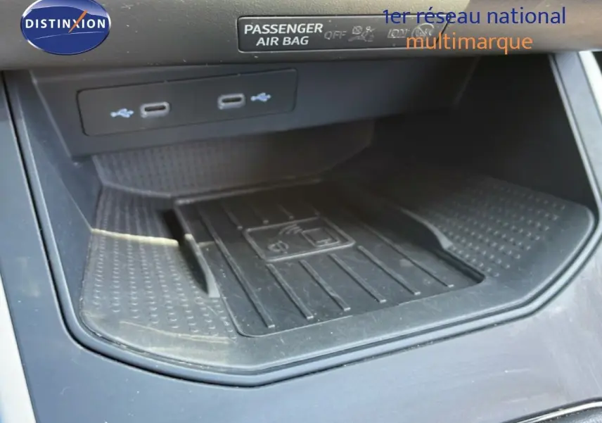 Gros plan sur la console centrale du SEAT Arona 2025, montrant le chargeur sans fil et deux ports USB.