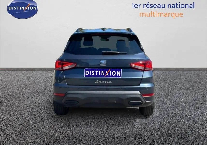 Vue arrière d’un SEAT Arona gris Magnetic Metal avec toit noir, mettant en valeur ses feux arrière et son logo central.