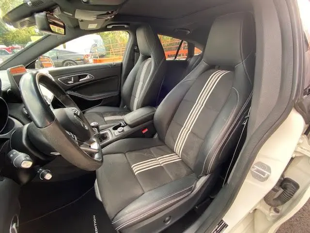 Intérieur côté conducteur d'une Mercedes CLA Shooting Brake 200D WhiteArt, sièges cuir noir avec bandes blanches.