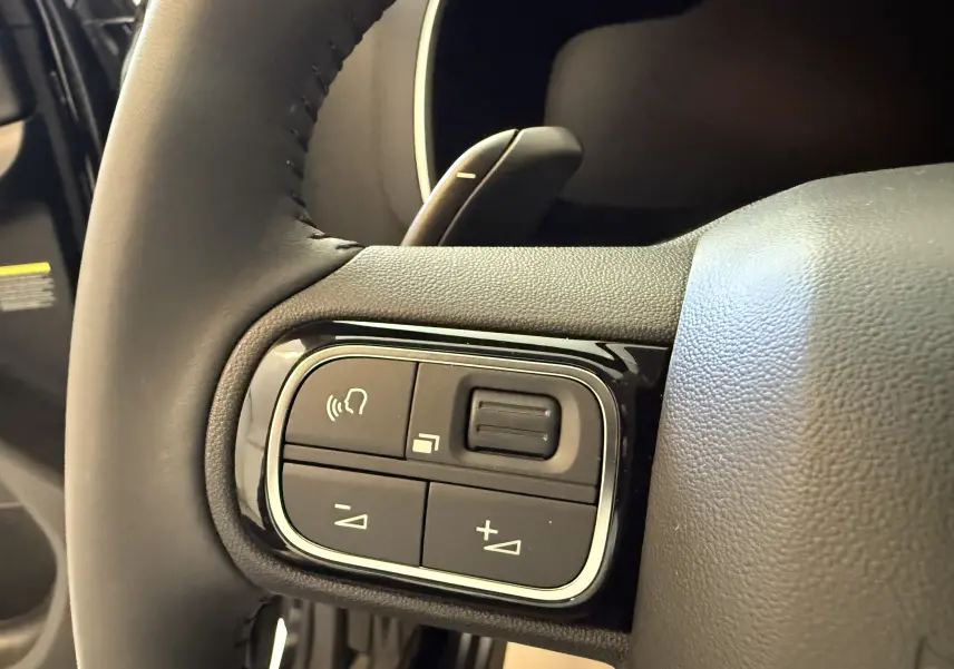 Gros plan sur les commandes du volant en cuir noir du Citroën C5 Aircross gris Artense 2022, version Shine.