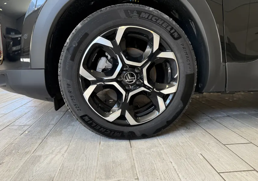 Gros plan sur la roue avant gauche du Citroën C5 Aircross gris Artense, jante alliage noire et argent avec pneu Michelin.