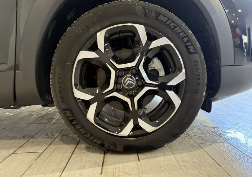 Gros plan sur la jante noire et argentée de 18 pouces avec logo Citroën sur un C5 Aircross gris Artense.