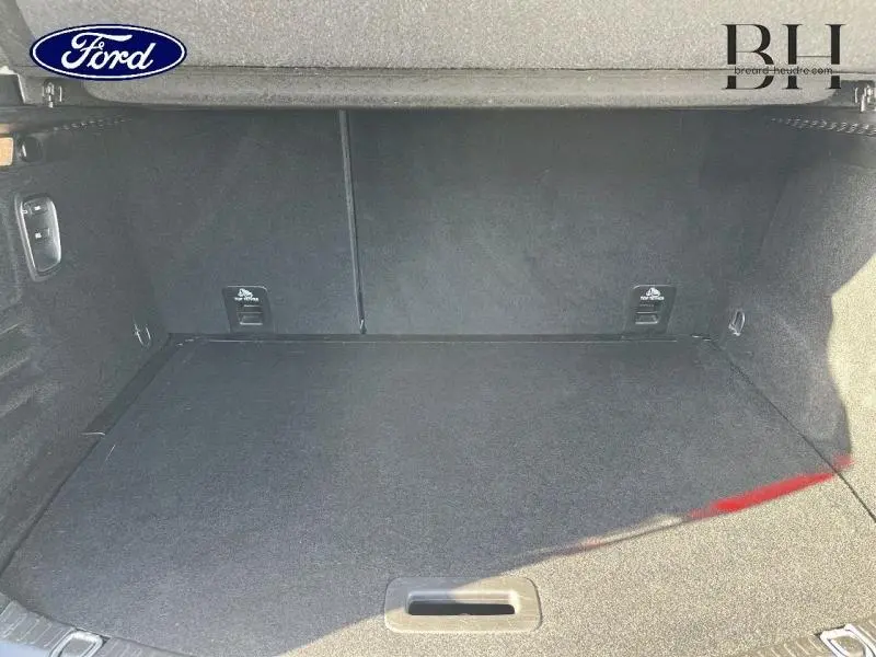 Coffre vide vu de face, revêtement noir, avec ancrages Isofix visibles sur un Renault Scenic blanc nacré/noir étoilé 2017.