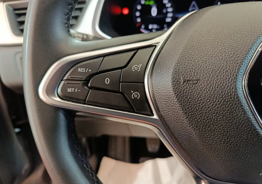 Gros plan sur le volant multifonctions noir du Renault Captur 2024, avec commandes de régulateur de vitesse visibles.