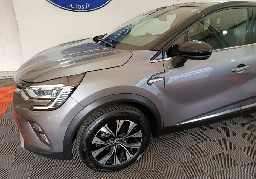 Vue 3/4 avant droit du Renault Captur 2024 gris foncé avec jantes alliage et feux LED distinctifs.