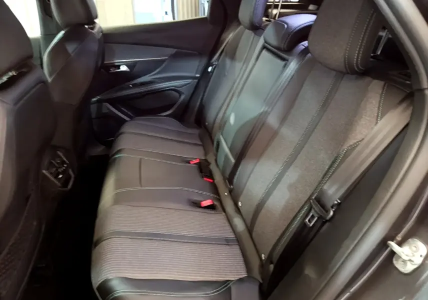 Vue intérieure côté droit des sièges arrière gris foncé du Peugeot 3008 hybride rechargeable 2022 avec coutures contrastées.
