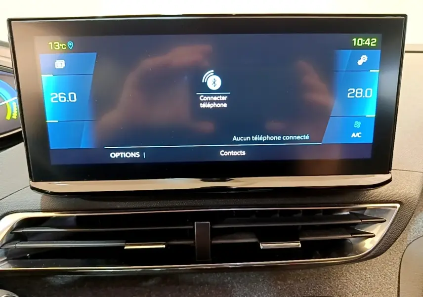Écran tactile central du tableau de bord du Peugeot 3008 gris foncé, affichant la climatisation et la connexion Bluetooth.