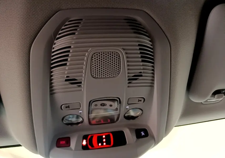 Vue en gros plan du plafonnier gris du Peugeot 3008 hybride 2022 avec boutons de commande et affichage lumineux rouge.