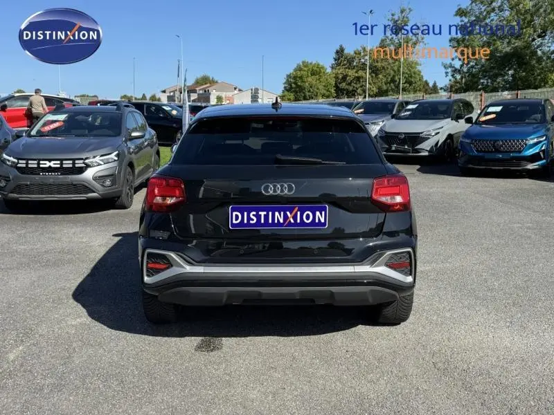 Vue arrière d'un Audi Q2 35 TFSI S line noir Mythic métallisé, soulignant ses feux rouges et détails chromés.