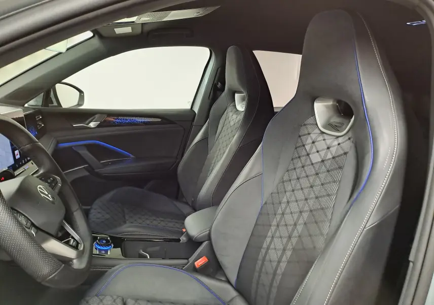 Vue intérieure côté conducteur du Volkswagen Tiguan 2.0 TDI R-Line avec sièges sport noirs et surpiqûres bleues.