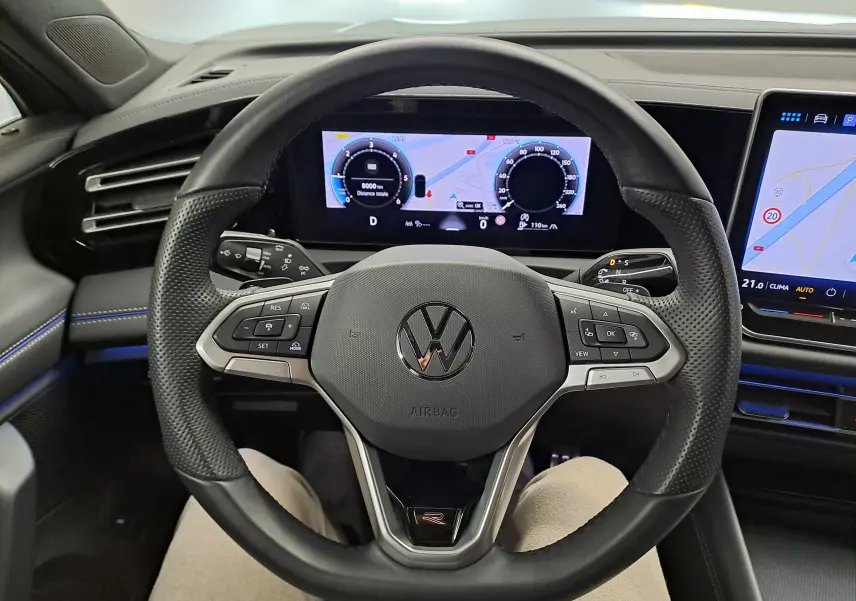 Vue intérieure centrée sur le volant multifonction du Volkswagen Tiguan 2.0 TDI R-Line avec tableau de bord numérique et écran tactile.
