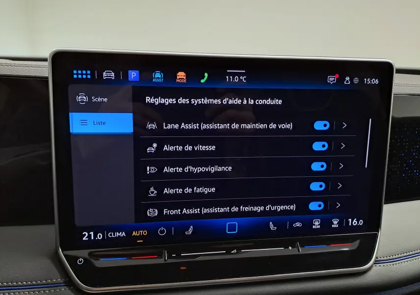 Écran tactile central du Volkswagen Tiguan 2025 affichant les réglages des aides à la conduite, intérieur avec surpiqûres bleues.