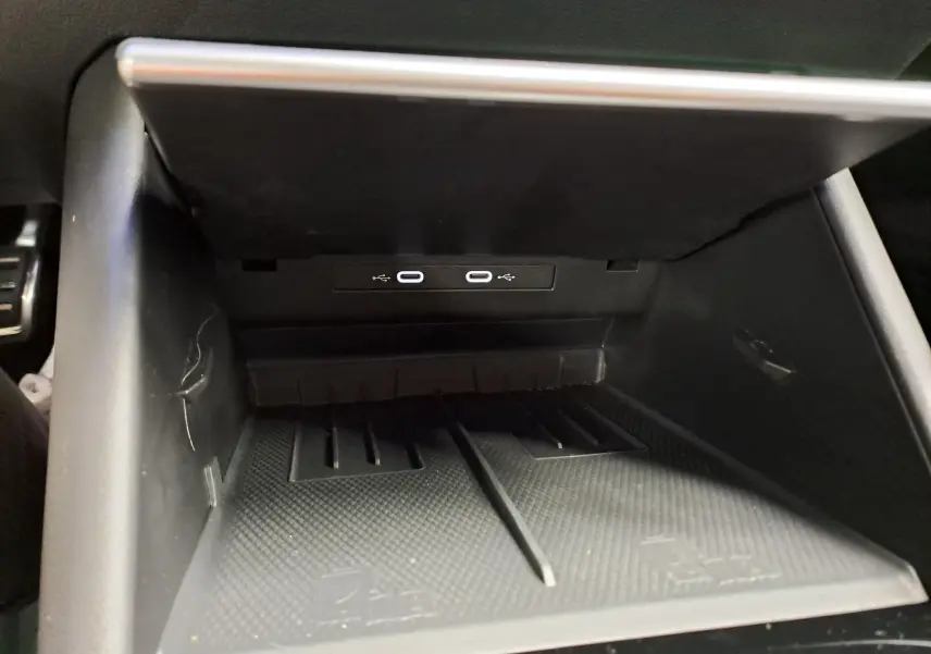 Gros plan sur la console centrale du Volkswagen Tiguan 2025, montrant deux ports USB-C intégrés dans un espace de rangement noir.