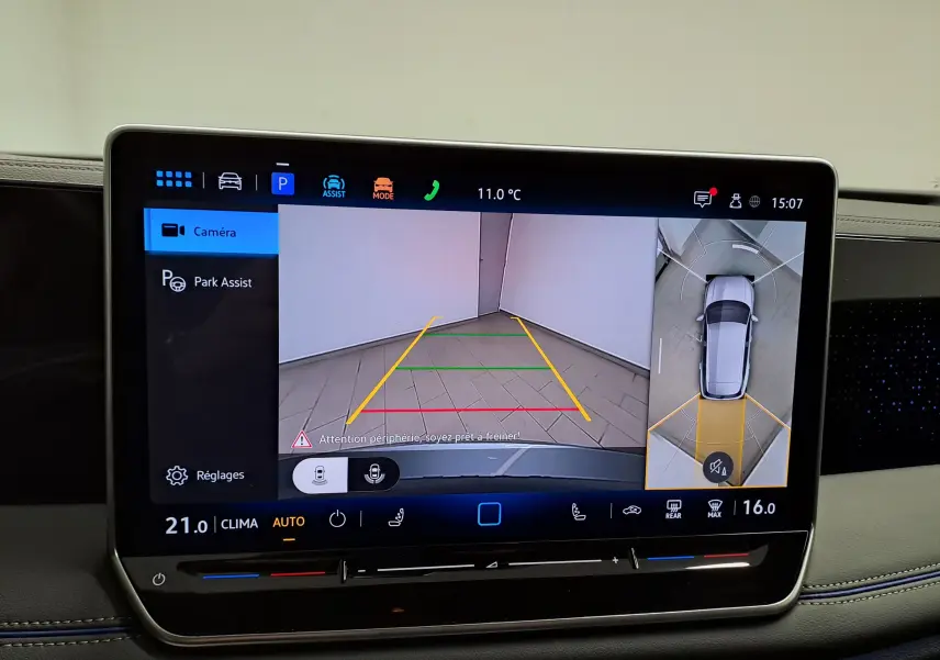 Écran tactile intérieur montrant l'aide au stationnement avec vue caméra et plan 360° du Volkswagen Tiguan argent Dolomite.
