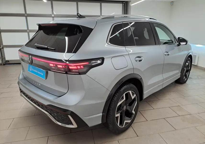 Volkswagen Tiguan 2.0 TDI 150 DSG7 R-Line argent Dolomite, vue 3/4 arrière droit avec feux LED et jantes distinctives.