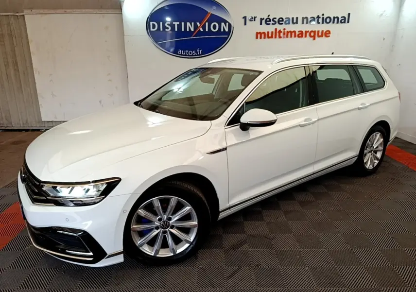 Volkswagen Passat 1.4 TSI hybride blanche vue 3/4 avant droit en intérieur showroom avec jantes alliage.