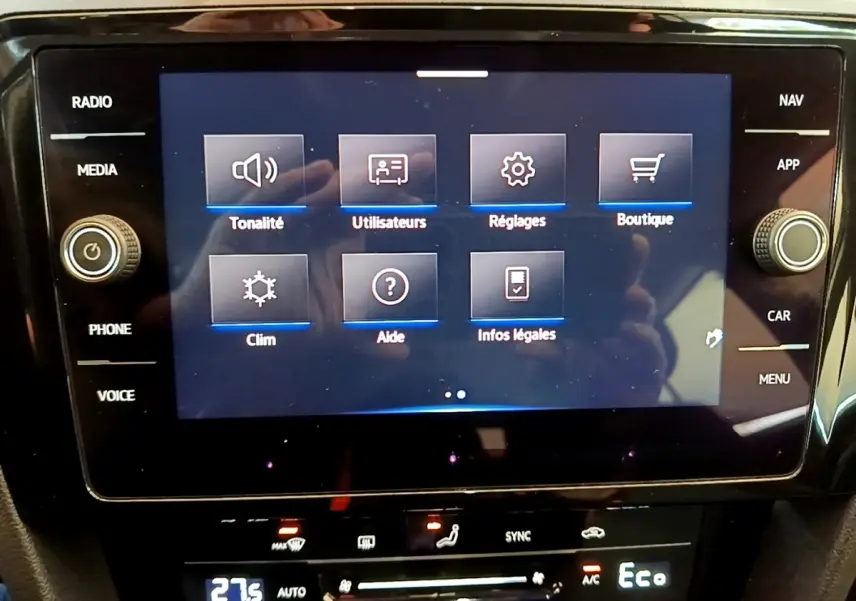 Écran tactile central affichant le menu principal de la Volkswagen Passat hybride blanche, vue de face intérieure.