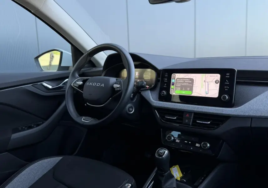 Intérieur de la Skoda Scala TSI 116 blanc Glacier, vue côté conducteur avec tableau de bord et écran tactile.