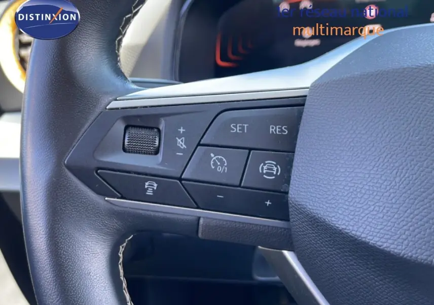 Gros plan sur le volant en cuir noir du SEAT Arona 2025, montrant les commandes de régulateur de vitesse et d'assistance.