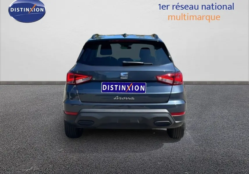 Vue arrière d’un SEAT Arona gris Magnetic Metal avec toit noir, affichant ses feux arrière et le logo distinctif.