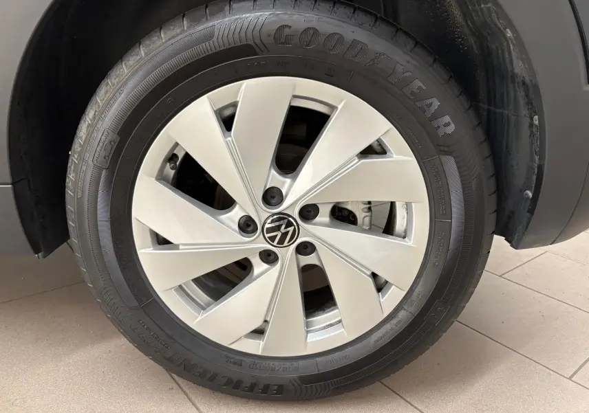 Gros plan sur la roue avant gauche du Volkswagen T-Cross noir intense avec jante alliage et pneu Goodyear.