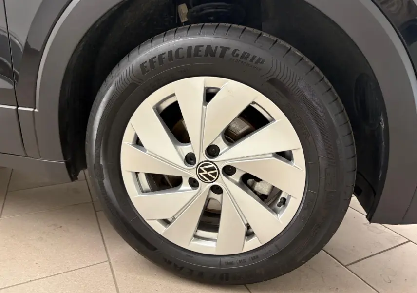 Gros plan sur la roue avant droite du Volkswagen T-Cross noir intense 2024 avec jante alliage et pneu EfficientGrip.