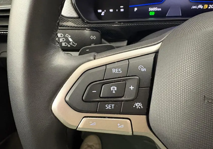 Gros plan sur les commandes de régulateur de vitesse au volant du Volkswagen T-Cross noir intense 2024.