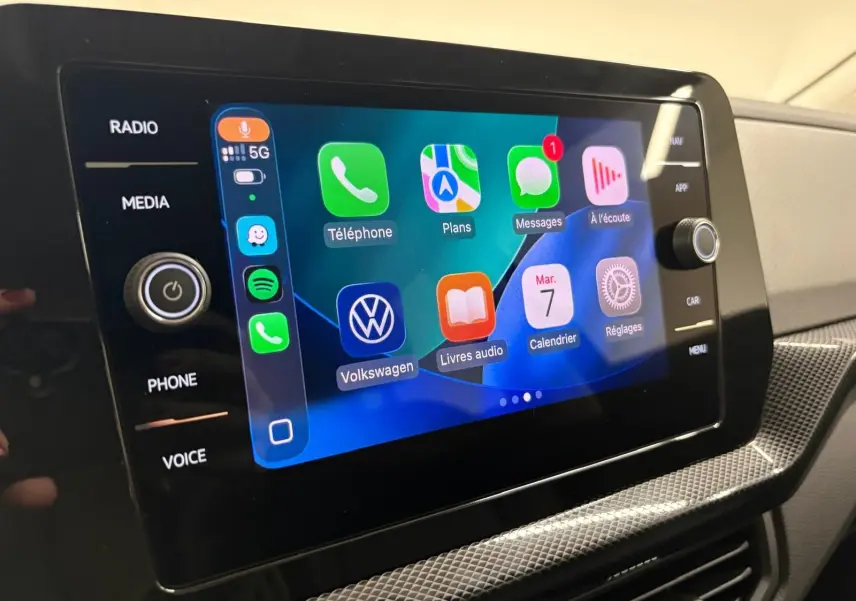 Écran tactile central du Volkswagen T-cross 2024 affichant les applications connectées, avec commandes autour et finition intérieure claire.